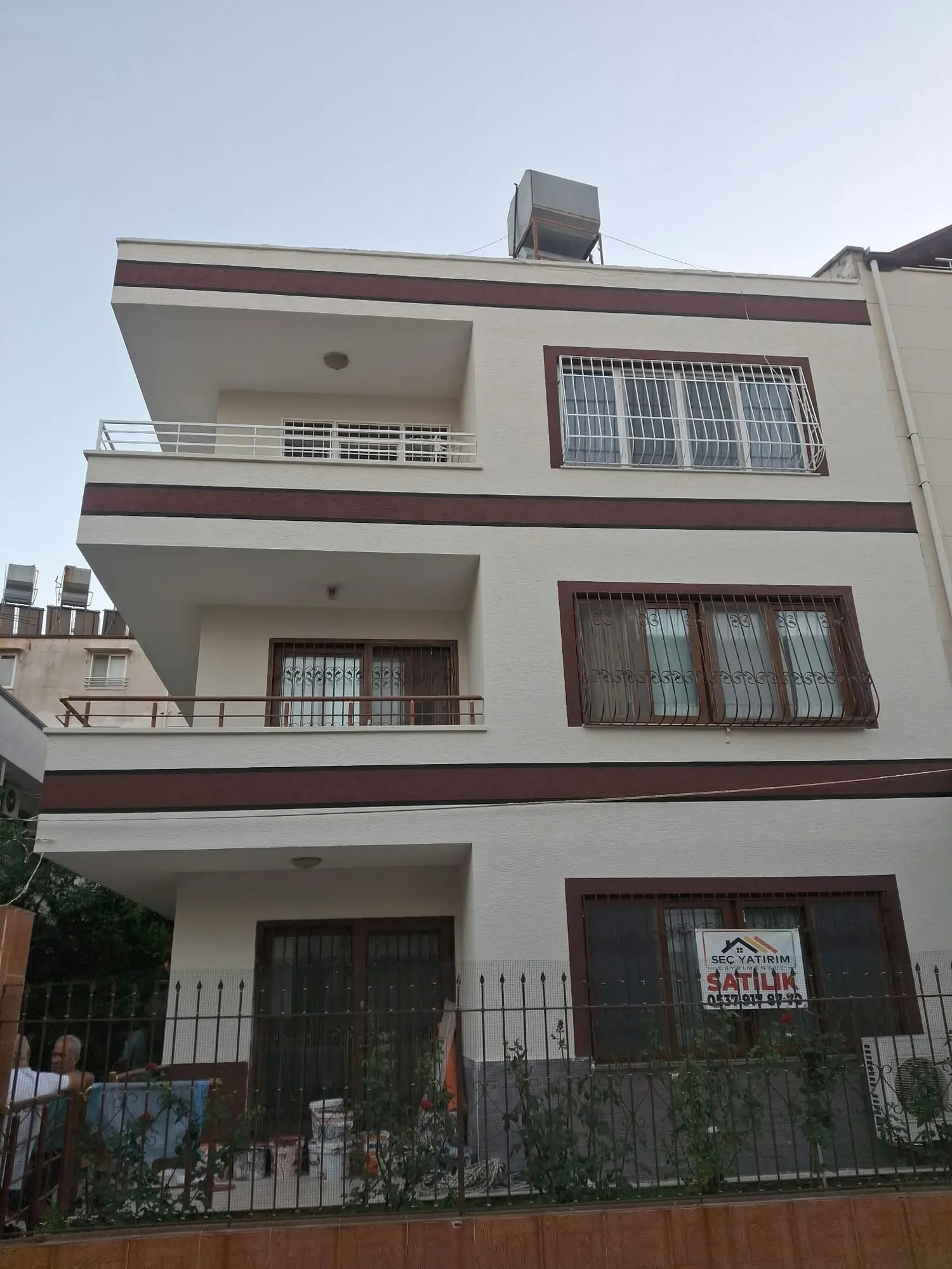 Bordo şerit detayı görünen yenilenmiş bina cephesi