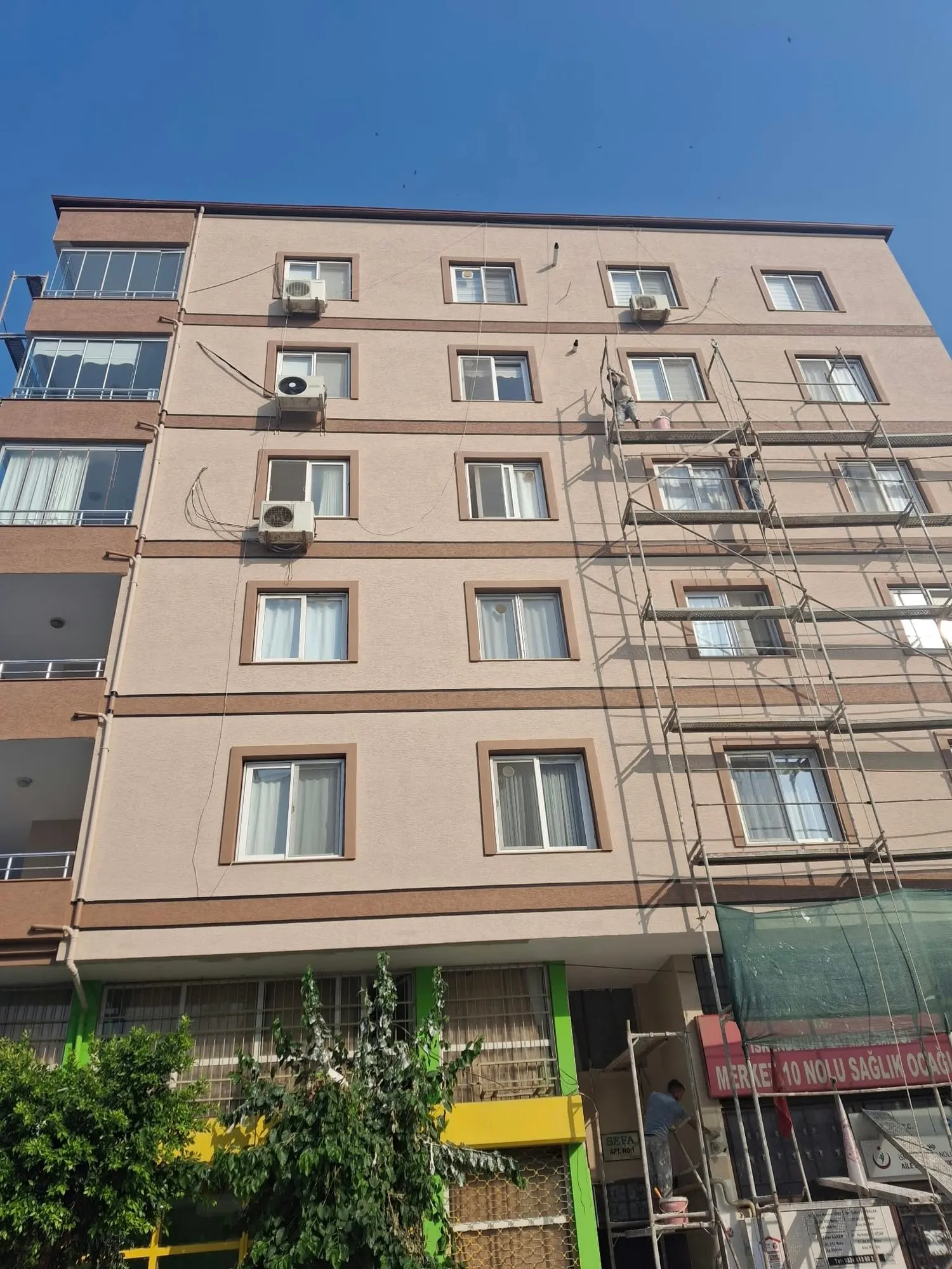 İskele kurulmuş binada devam eden dış cephe uygulaması
