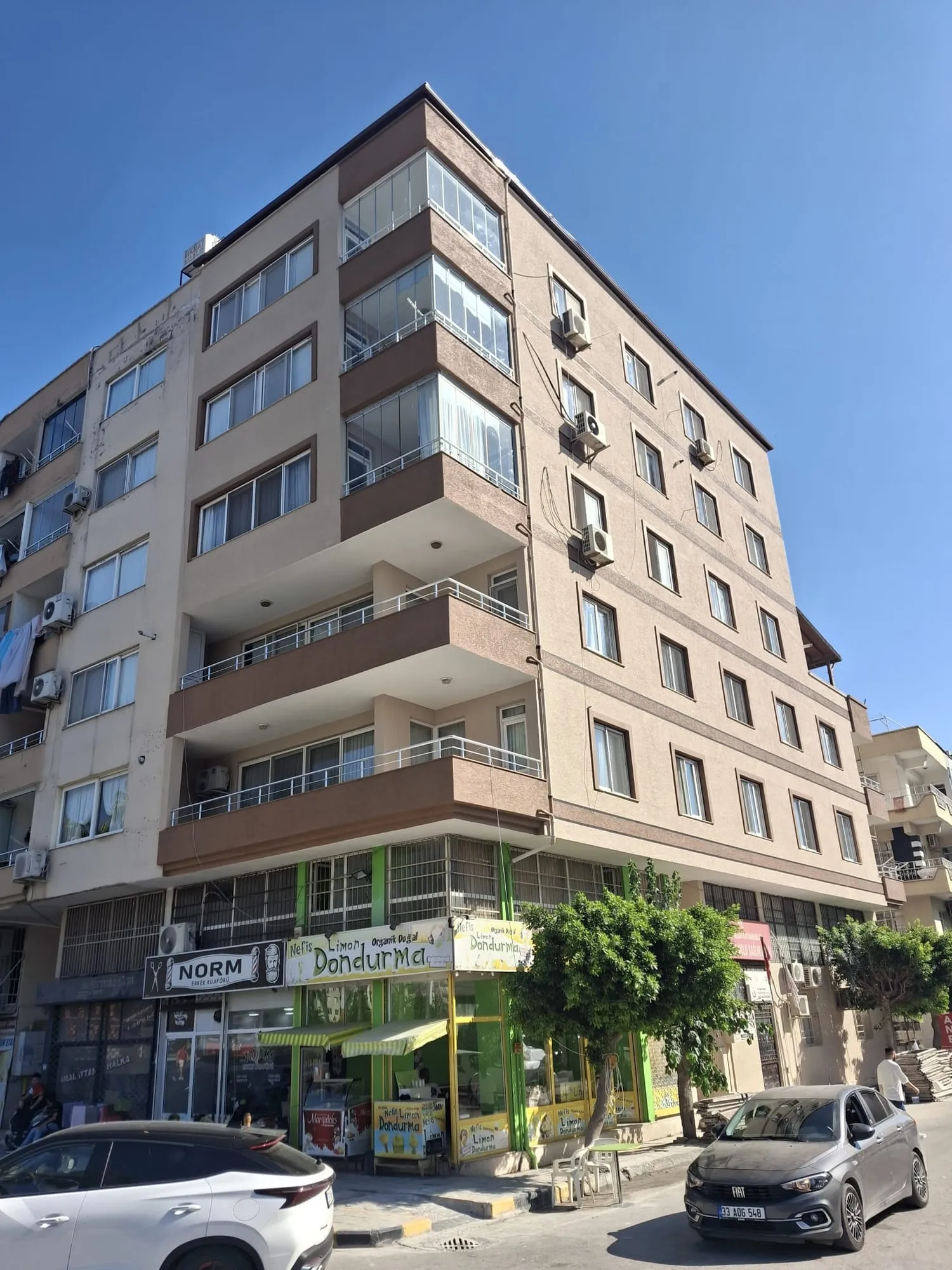 Zemin katında dükkânlar bulunan köşe apartmanın yenilenmiş cephesi