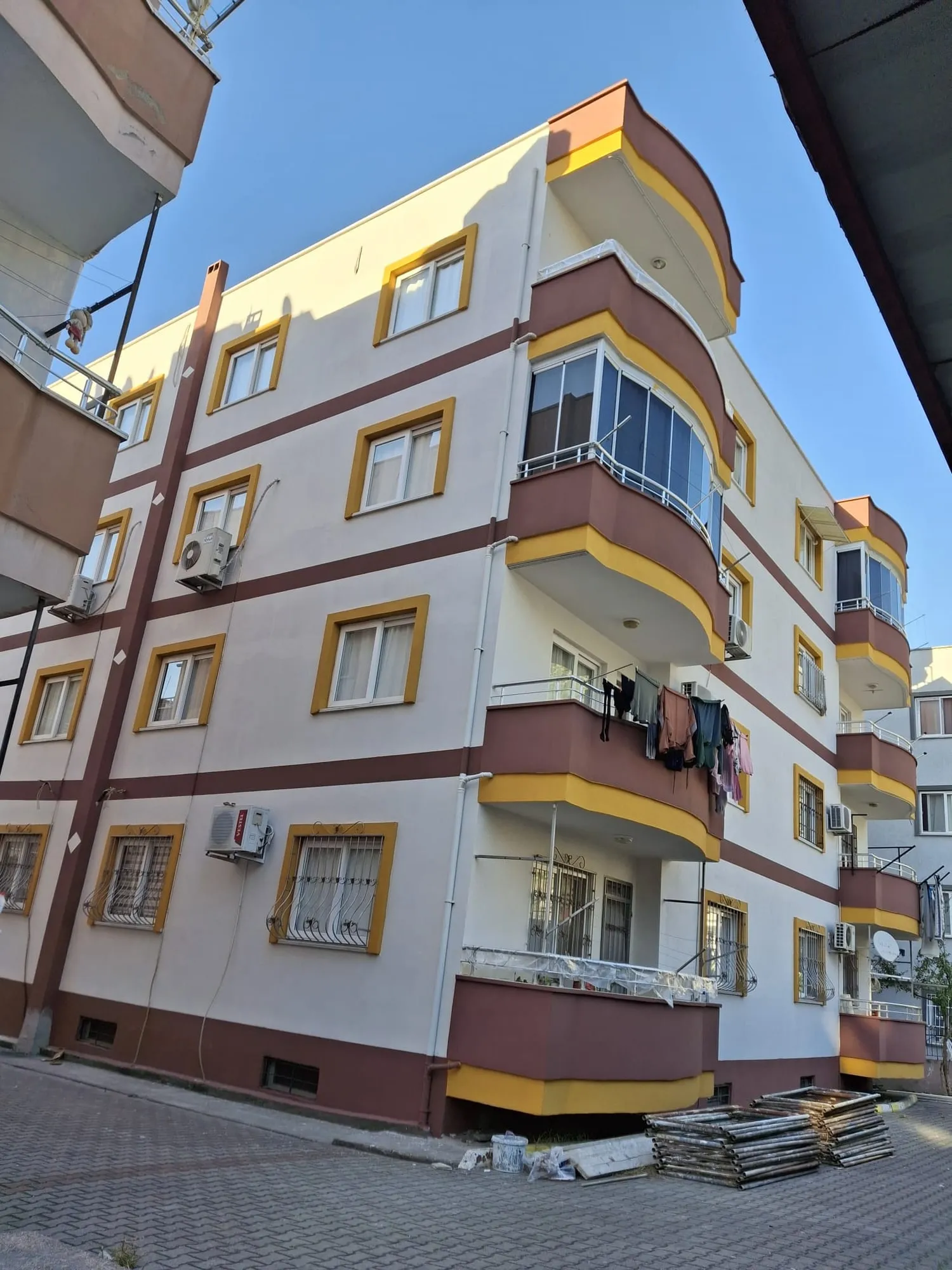 Krem ve sarı tonlarında boyanmış apartman dış cephesi