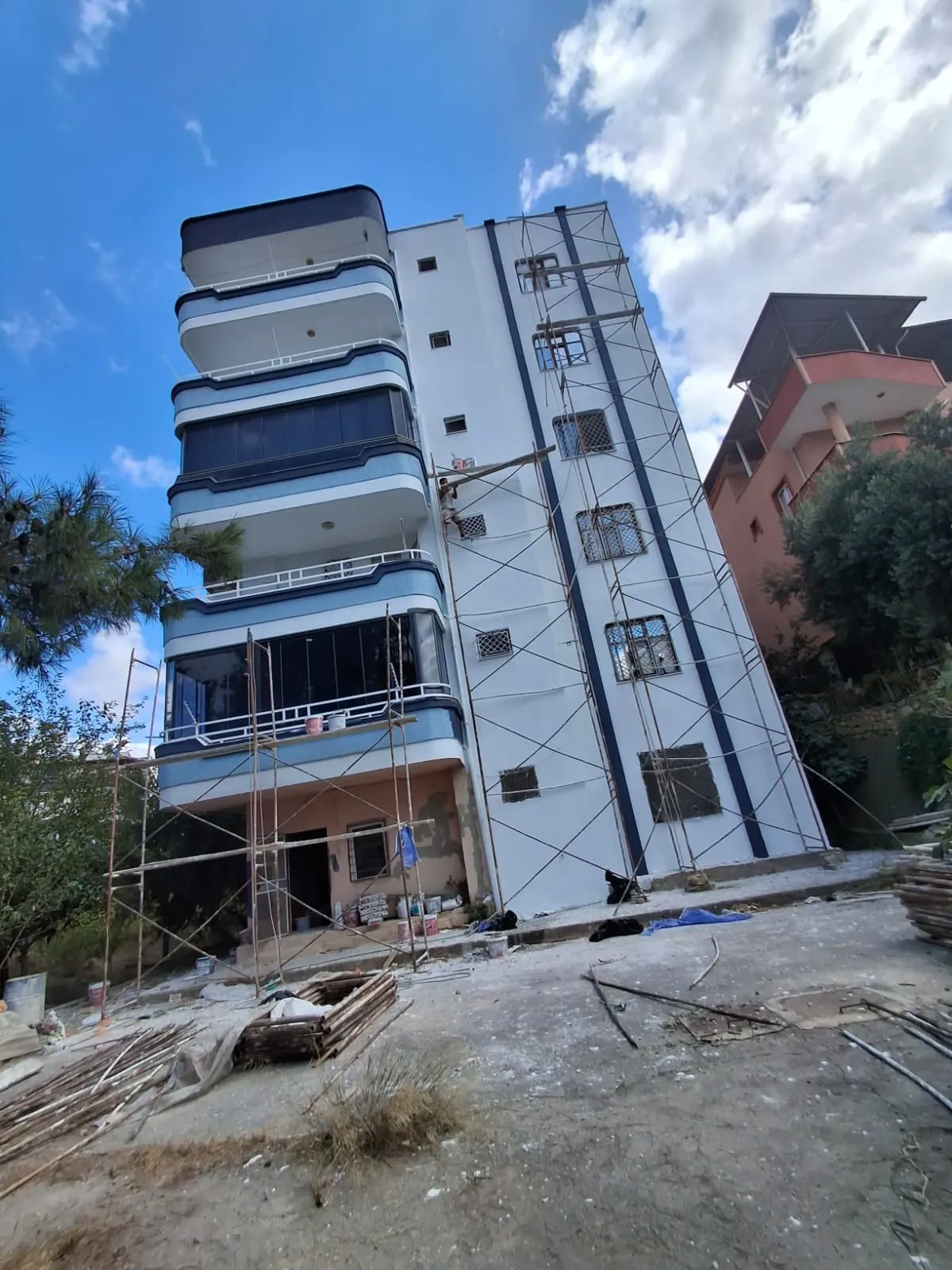 Cephe uygulaması devam eden mavi beyaz renkli bina